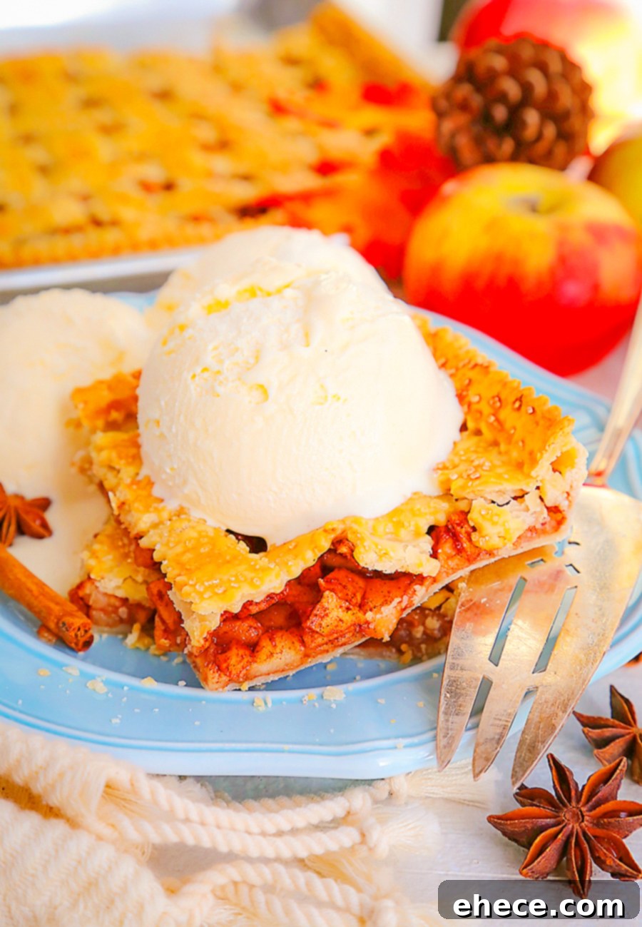 Sheet Pan Apple Pie Perfection 4 A close-up of a freshly baked Apple Slab Pie, showing the golden-brown, bubbly filling through the lattice crust. Perfect for a holiday dessert table.