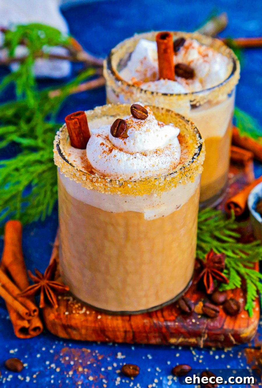 A beautifully presented glass of Espresso Chai Eggnog with a sugar rim and frothy whipped cream, capturing the festive mood.