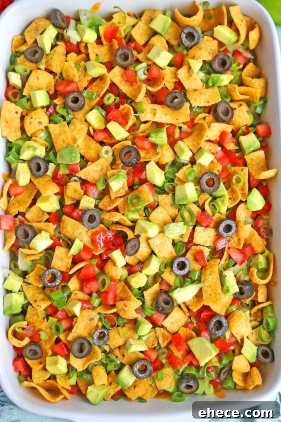 Layers of refried beans, sour cream, seasoned meat, and cheddar cheese for an easy taco casserole.