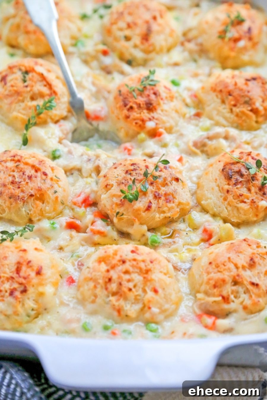 An overhead shot of Chicken Pot Pie in a casserole dish, with a slice removed, revealing the rich filling.