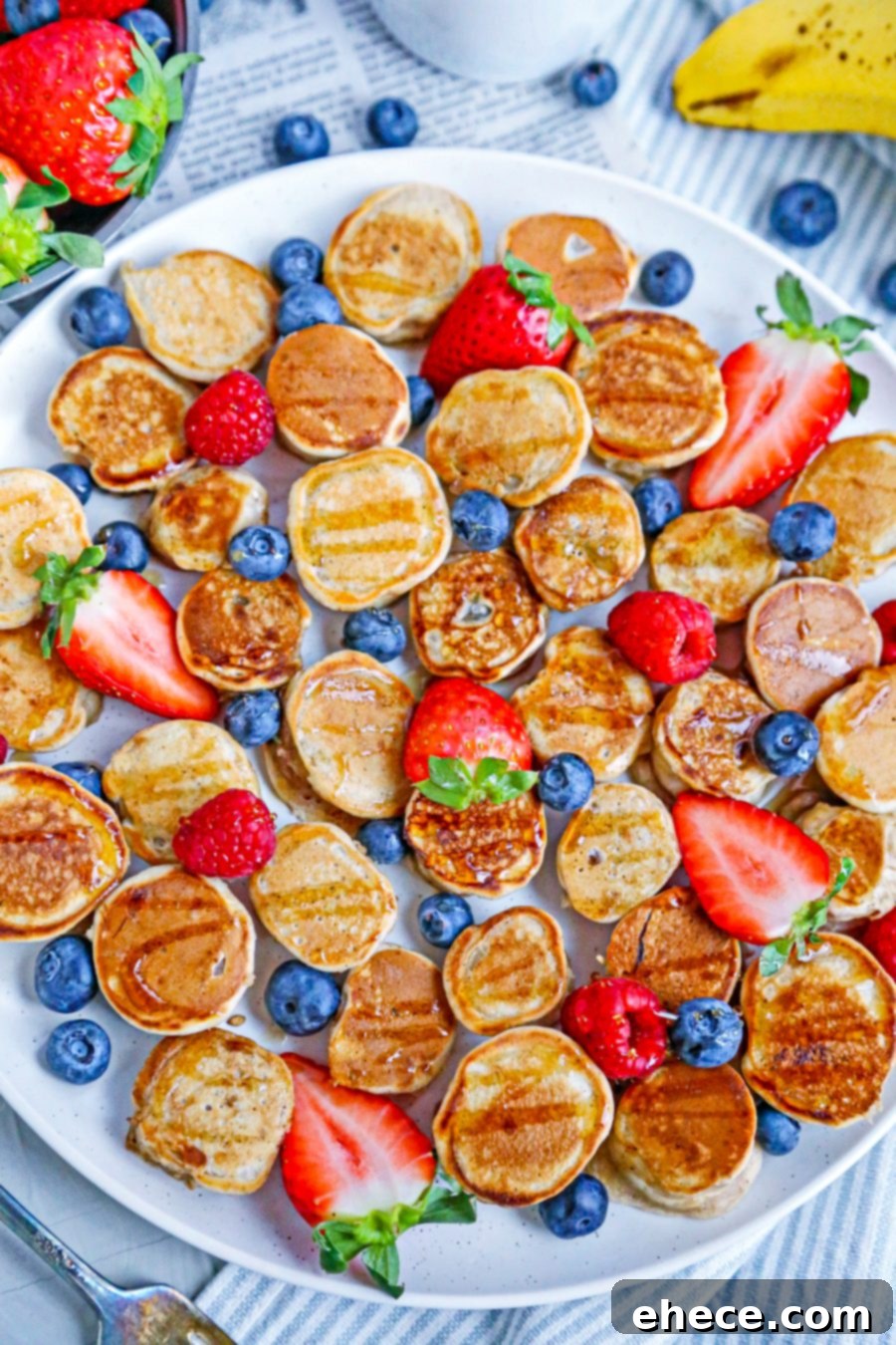 Close-up of golden banana pancake bites on a white plate, ready to be served