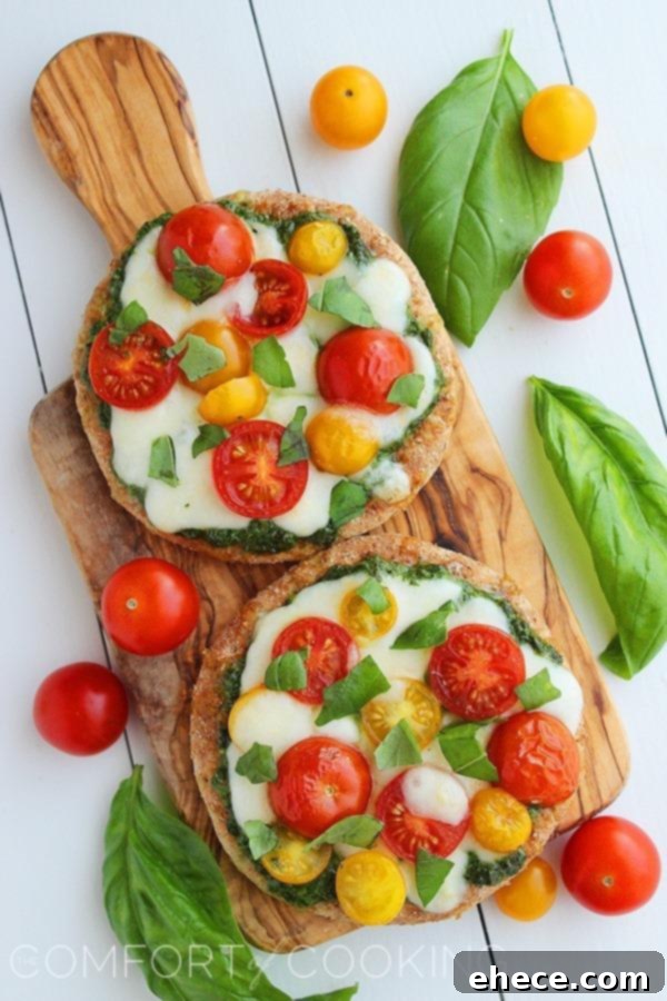 Wholesome Pesto Caprese Mini Pizzas 5 Another appealing shot of Mini Whole Wheat Pesto Caprese Pizzas with fresh ingredients, garnished with basil leaves.