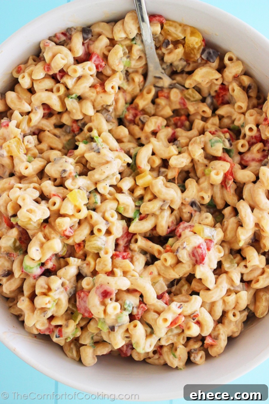 Homemade Macaroni Salad ready to be served at a summer party, highlighting its rich, creamy texture and colorful ingredients.