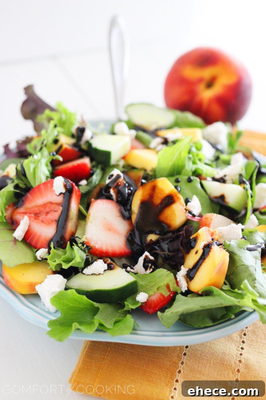 Summer Strawberry-Peach Salad with Goat Cheese – A platter of the colorful and healthy salad, ready to be served at a summer gathering.