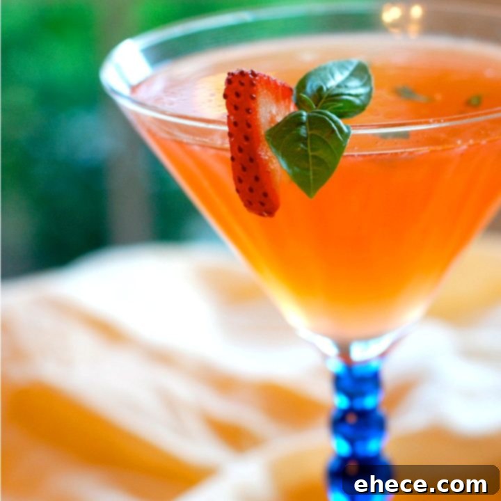 Vibrant Strawberry Basil Cocktail in a glass, garnished with fresh strawberry slices and basil leaves, perfect for summer