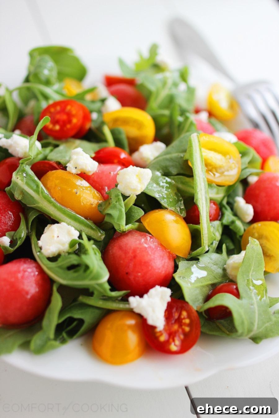 Juicy Watermelon, Tangy Feta, Peppery Arugula: A Zesty Summer Salad 4 A bowl of Watermelon Feta Arugula Salad garnished with fresh herbs, ready to serve.