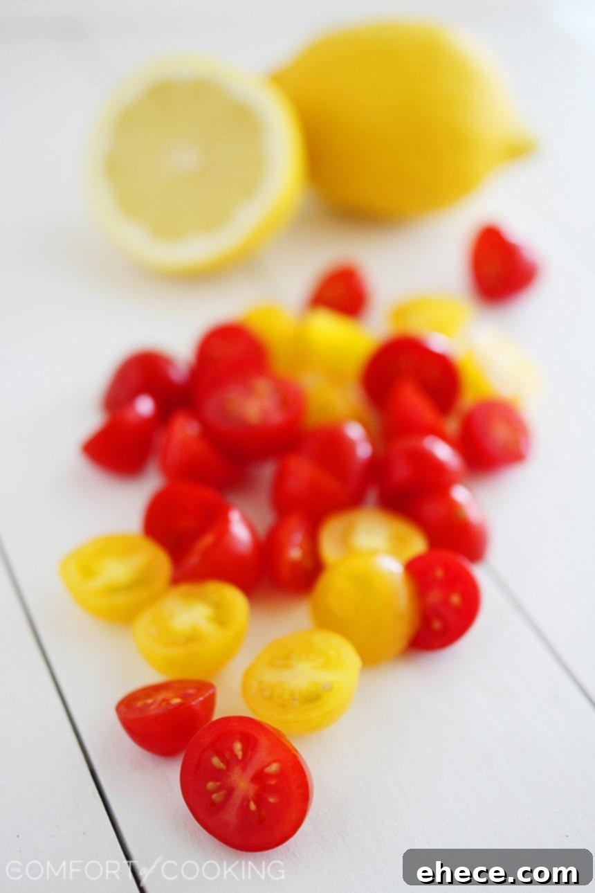 Close-up of creamy zucchini noodles with halved cherry tomatoes, ready to be served as a healthy meal.