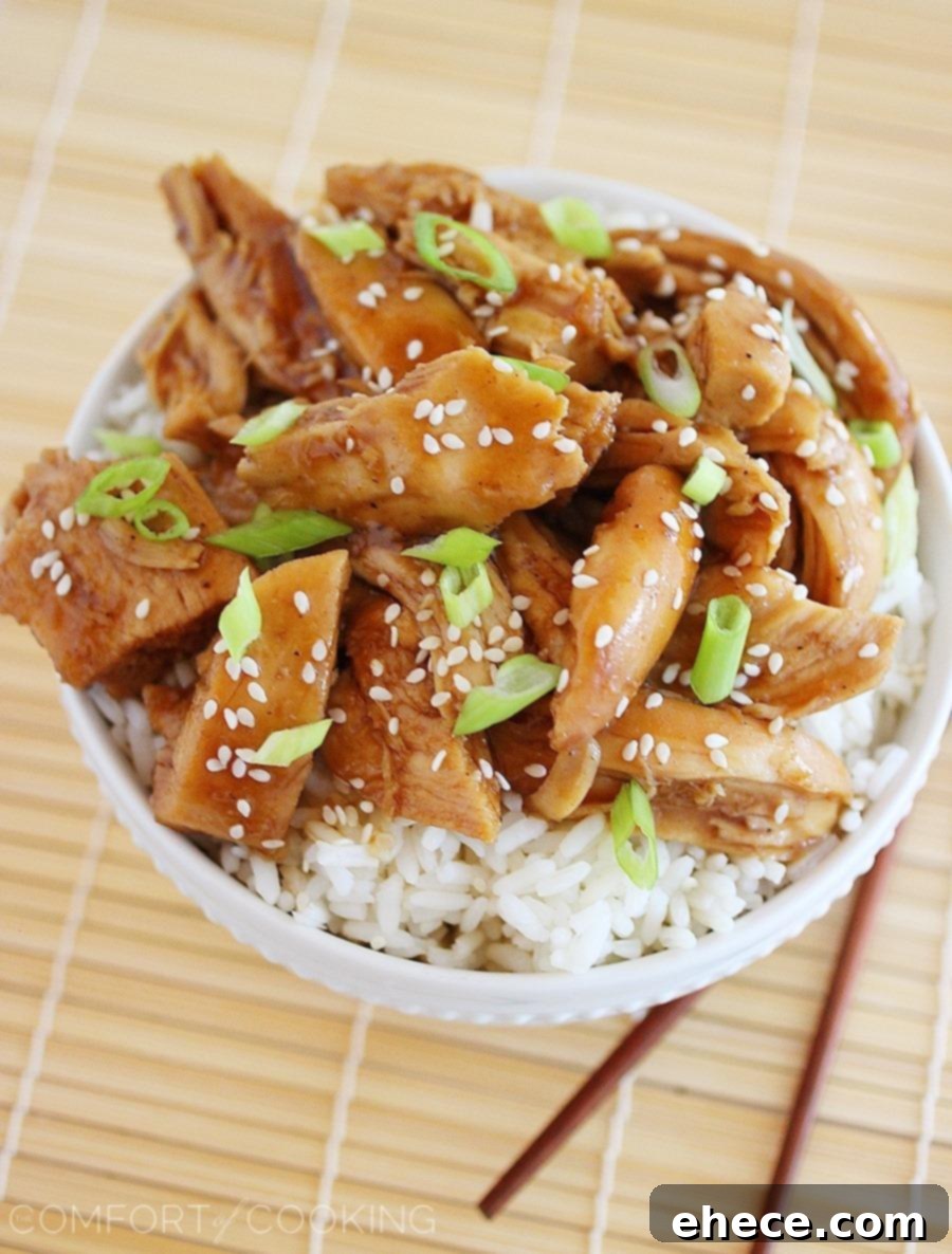 Serving bowl filled with Slow Cooker Teriyaki Chicken, garnished with sesame seeds and fresh green onions, ready to be enjoyed.