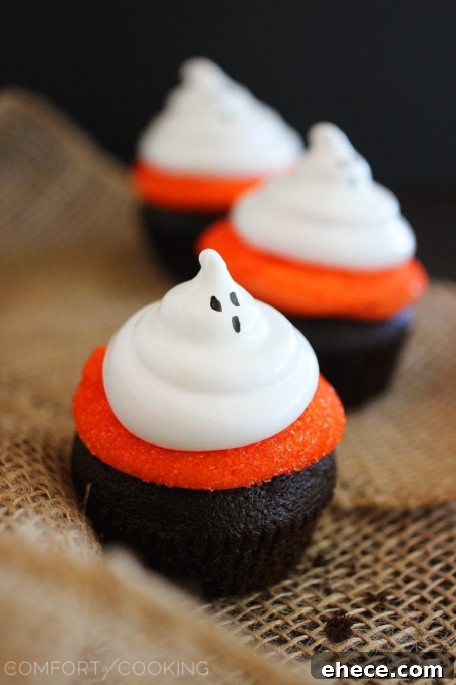 Collection of Dark Chocolate Cupcakes with Meringue Ghosts, featuring vibrant orange frosting and spooky faces