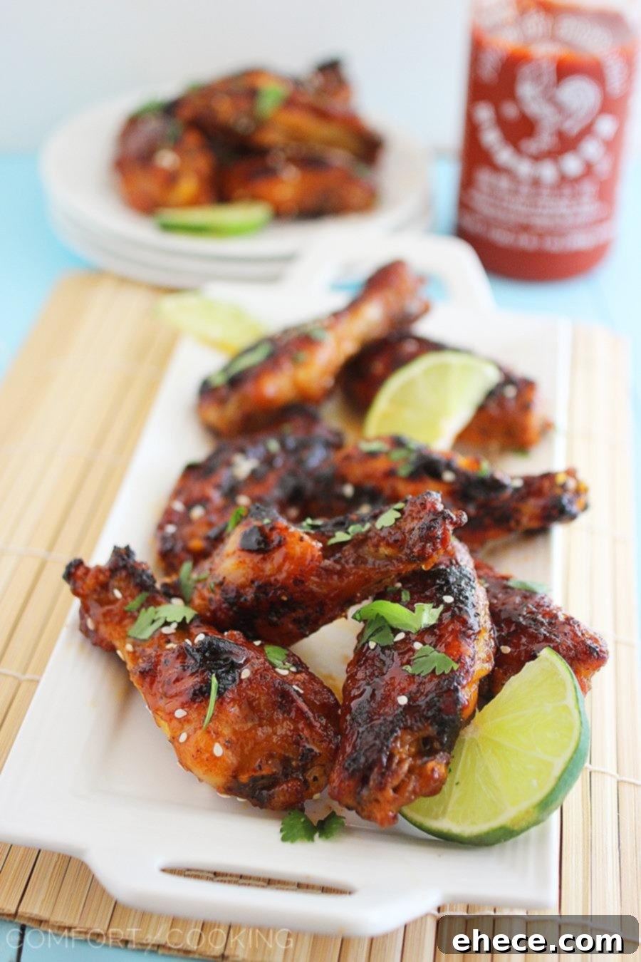 Crispy baked chicken wings coated in a glistening honey-sriracha glaze, garnished with sesame seeds and fresh cilantro. A perfect appetizer for parties and game day.