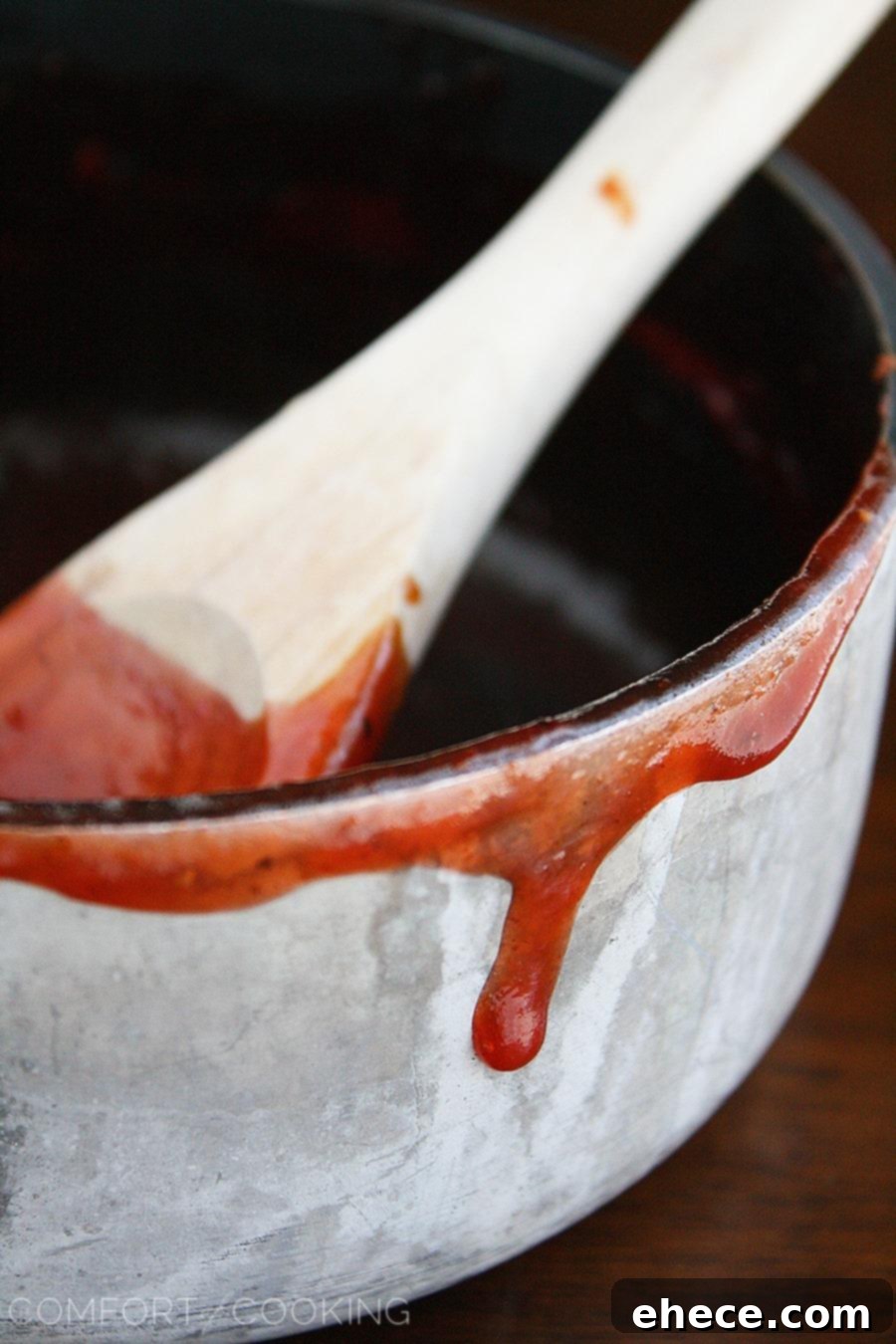 Close-up of golden-brown baked chicken wings on a baking sheet, ready to be tossed in the sweet and spicy sauce.