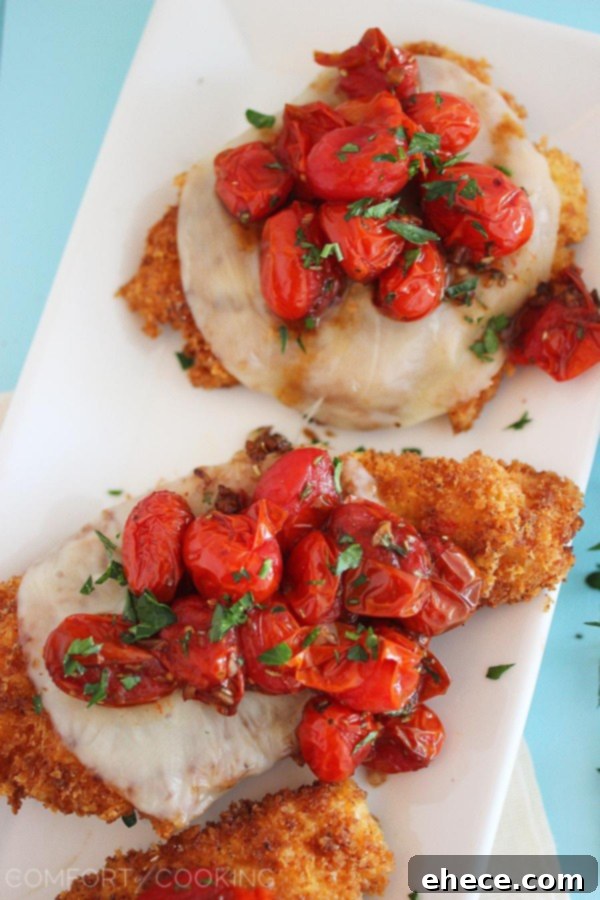 Plated Crispy Parmesan Chicken with Balsamic Roasted Tomatoes and fresh parsley