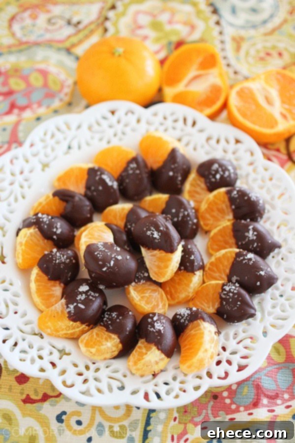 Sea Salted Dark Chocolate Clementine Delights 2 Delicious chocolate-dipped clementine segments sprinkled with sea salt, arranged beautifully on a plate.