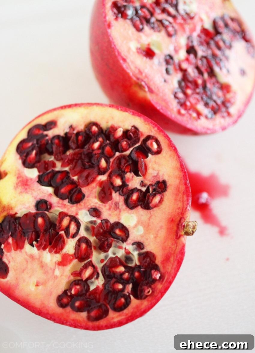 Jeweled Greens with Feta and Pecans 4 Close-up of colorful salad ingredients: mixed greens, vibrant pomegranate seeds, and creamy feta cheese.