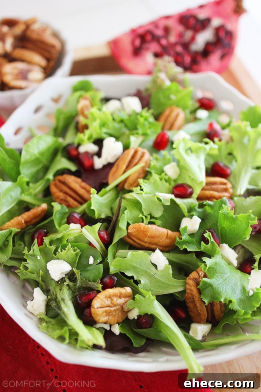 Jeweled Greens with Feta and Pecans 5 A fresh bowl of Mixed Green Salad, generously topped with pomegranate seeds, feta cheese, and whole pecan halves.