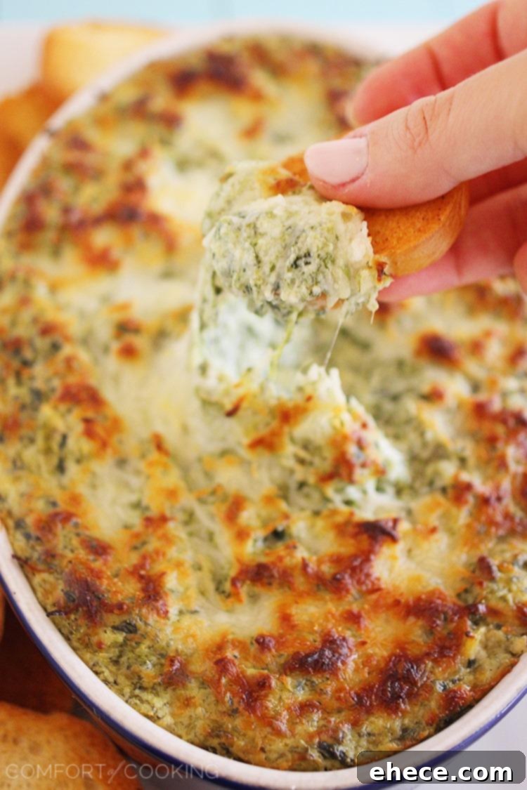 Close-up of Hot Cheesy Spinach-Artichoke Dip, showing its creamy texture and melty cheese. The perfect warm appetizer for any gathering.