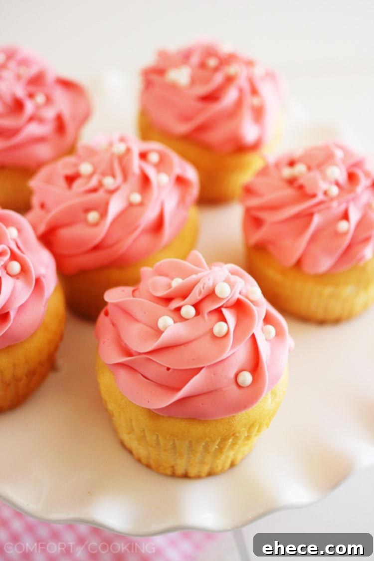 Sparkling Rosé Cupcakes 5 Close-up of pink champagne cupcakes arranged artfully on a white surface.