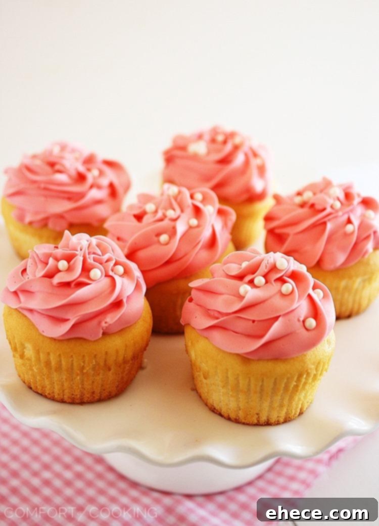 Sparkling Rosé Cupcakes 6 A plate of pink champagne cupcakes ready for serving, garnished with delicate edible pearls.