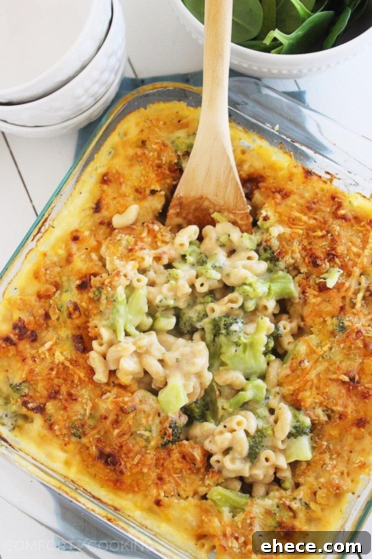 A large serving of skinny baked broccoli mac and cheese on a plate, garnished with fresh herbs.