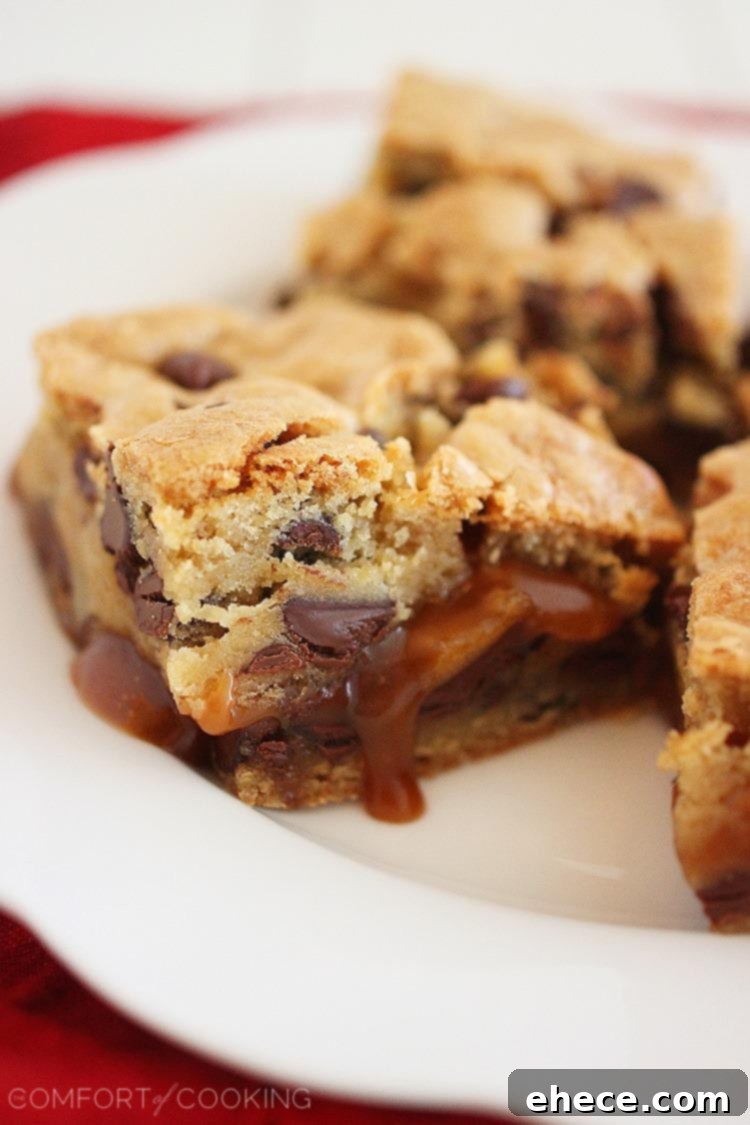 A tray of freshly baked Salted Caramel Chocolate Chunk Cookie Bars cooling on a wire rack, exhibiting a perfect golden-brown top crust.