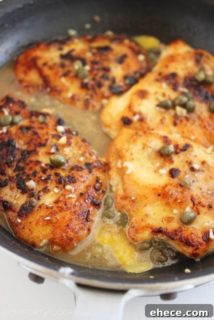 Crispy chicken cutlets drizzled with lemon caper sauce, served with pasta and a green salad, capturing the essence of a light and zesty dinner.