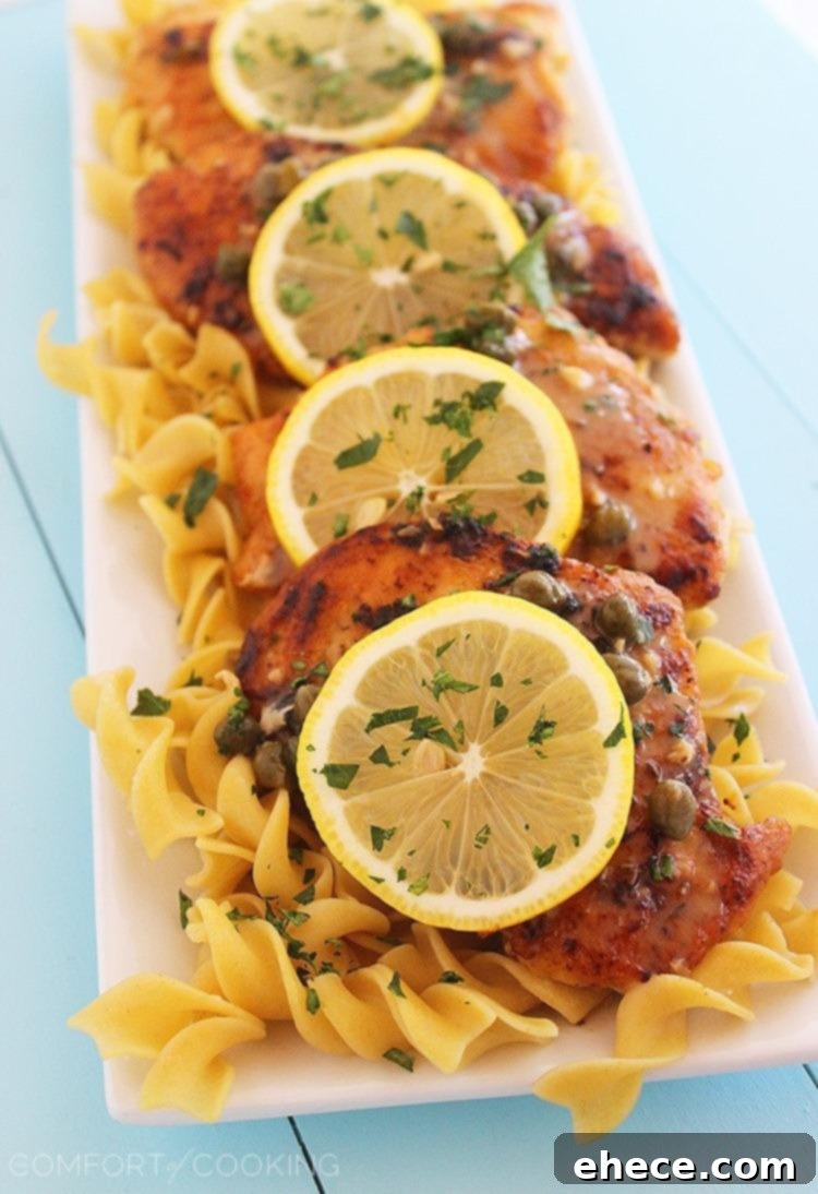 Close-up of a perfectly cooked chicken piccata cutlet with lemon slices and capers, highlighting the tender and moist texture.