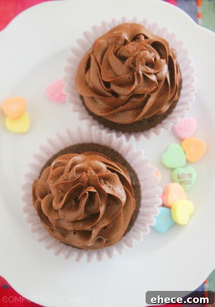Hand holding a small-batch chocolate cupcake with rich Nutella frosting, showcasing its moist texture.