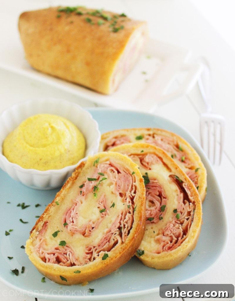 Three-Ingredient Baked Ham and Cheese Swirls 2 Golden brown 3-Ingredient Baked Ham and Cheese Rollups fresh out of the oven, highlighting the crispy crust and melted cheese inside.