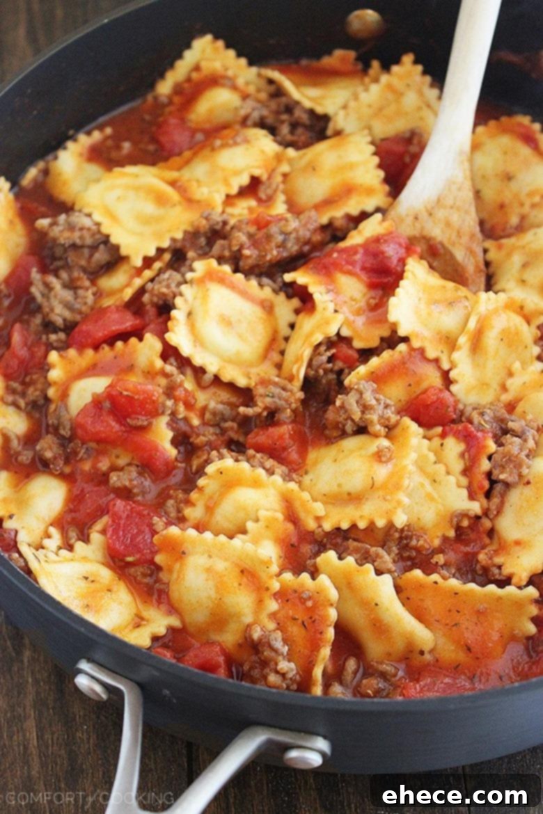 Close-up of the bubbling tomato sauce and ravioli in the skillet.