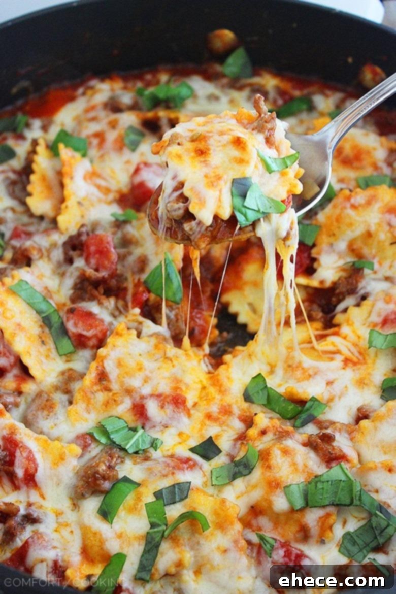 Ready-to-serve Cheesy Ravioli and Italian Sausage Skillet, garnished with fresh basil.