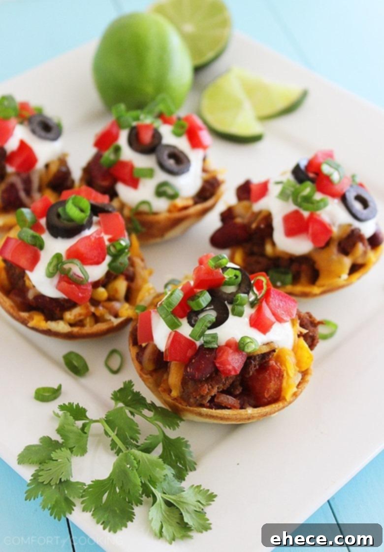Mini Mexican Chili Tortilla Cups – Hearty, cheesy chili scooped into crisp tortilla shells makes these a huge hit for parties and weeknights! | thecomfortofcooking.com