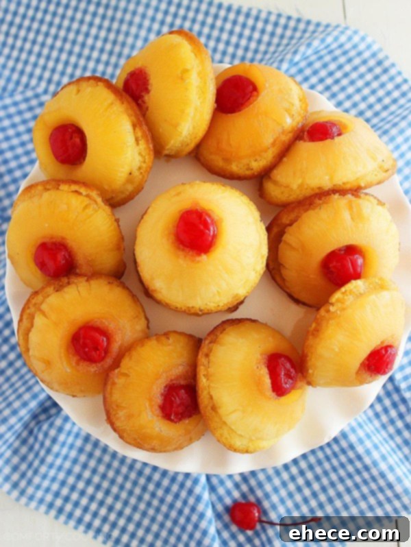 A single Mini Pineapple Upside Down Cake displayed on a delicate white plate, ready to be enjoyed as a light and delicious dessert. | thecomfortofcooking.com