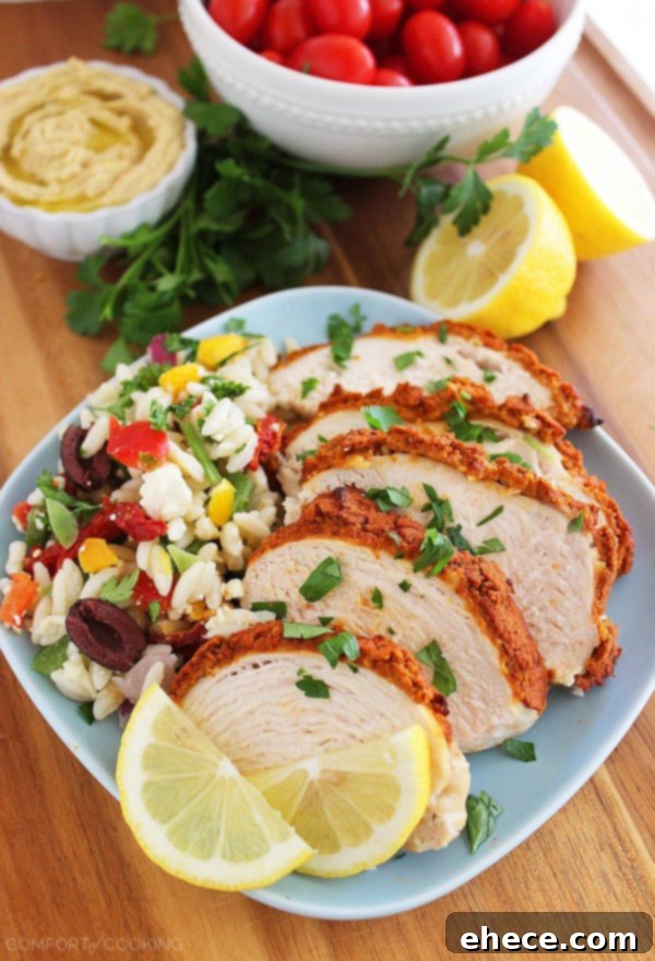 Freshly baked hummus-crusted lemon chicken served with a vibrant side salad, showcasing a perfect healthy meal.