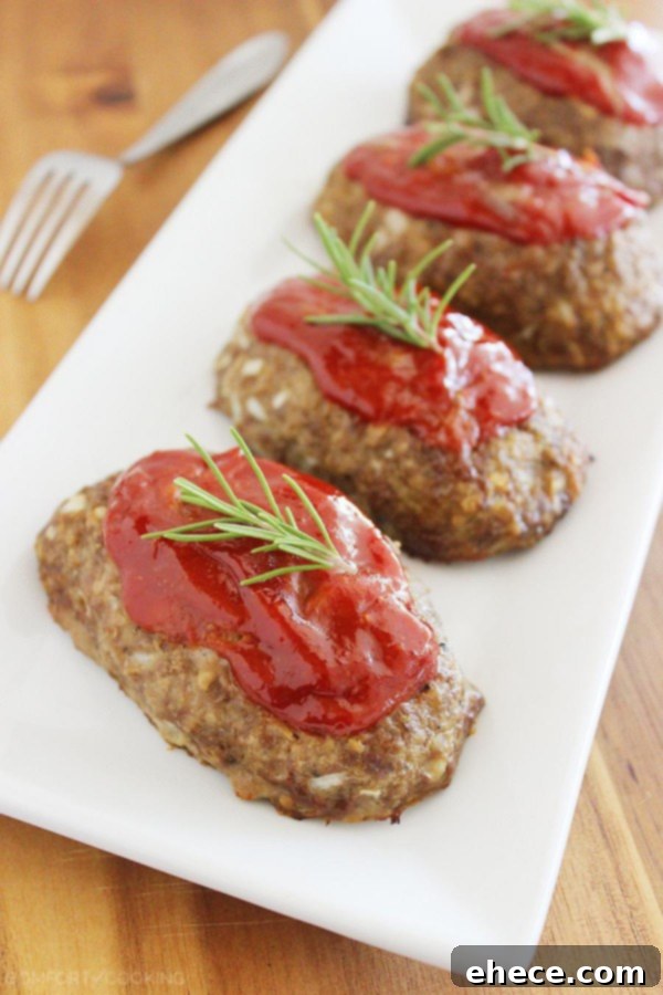Irresistible Italian Mini Meatloaves with a Mozzarella Surprise 3 Close-up of a Mozzarella-Stuffed Mini Meatloaf on a baking sheet, showcasing its golden crust and delicious topping.