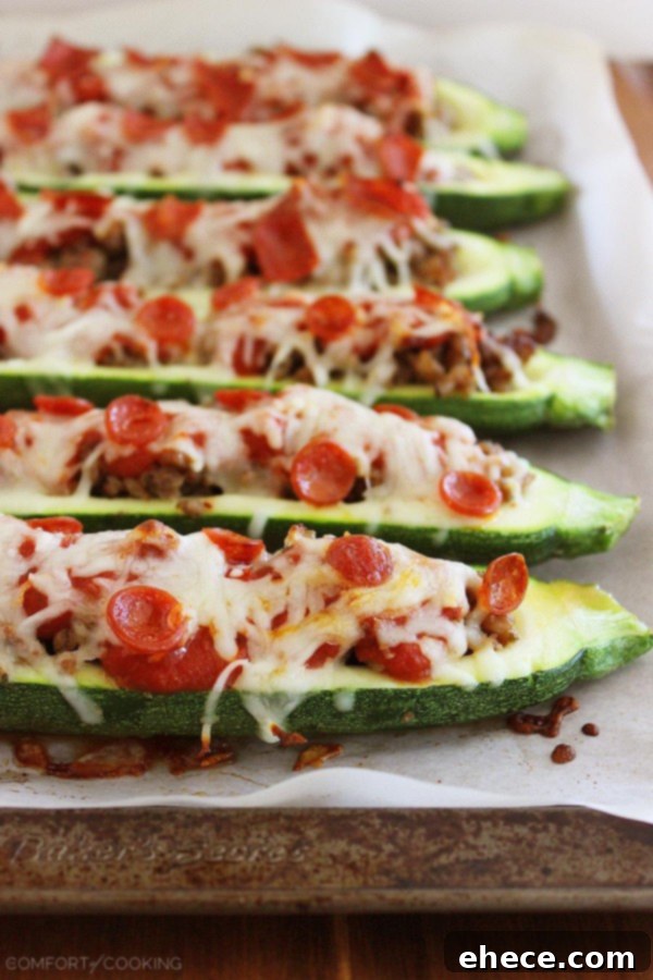 Zucchini Pizza Boats 4 Three Pizza Zucchini Boats cooling on a baking sheet, showcasing the bubbly cheese and toppings