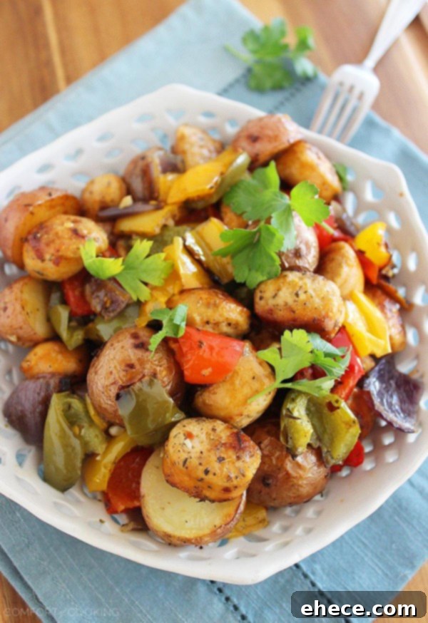 A full sheet pan filled with perfectly roasted chicken sausage, bell peppers, and potatoes, hot out of the oven.