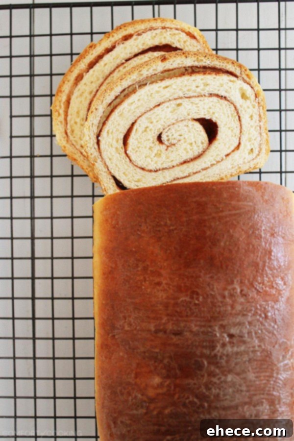 Two golden-brown loaves of Soft Cinnamon Swirl Bread cooling on a wire rack, ready to be enjoyed.