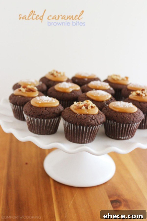 A top-down shot of mini Salted Caramel Brownie Bites, some topped with pecans, others with sea salt, arranged on a rustic wooden surface.