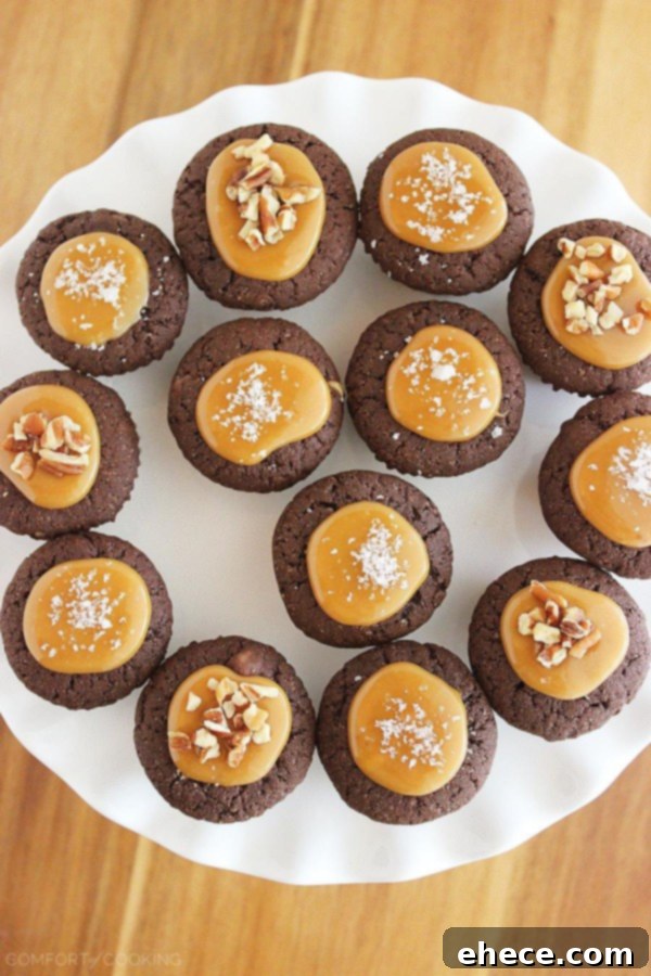 A plate of freshly prepared Salted Caramel Brownie Bites, garnished with sea salt and chopped pecans, ready to be served.