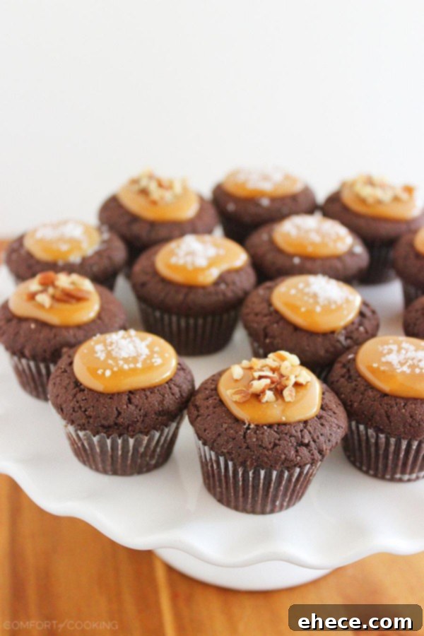 Stack of four Salted Caramel Brownie Bites on a white plate, highlighting the glossy caramel and toppings.