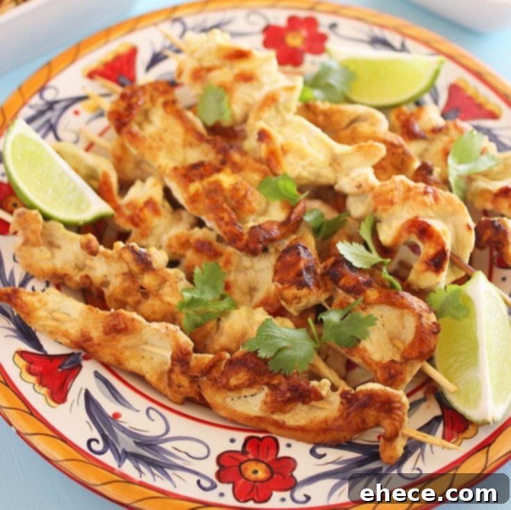 Beautifully presented Coconut-Ginger Chicken Satay with Sriracha sauce, ready to be enjoyed.