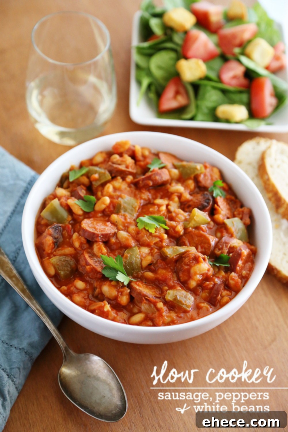 Savory Sausage, Peppers & White Bean Pot 2 Close-up of hearty slow cooker sausage, peppers, and white beans dish in a rustic bowl, garnished with fresh parsley.