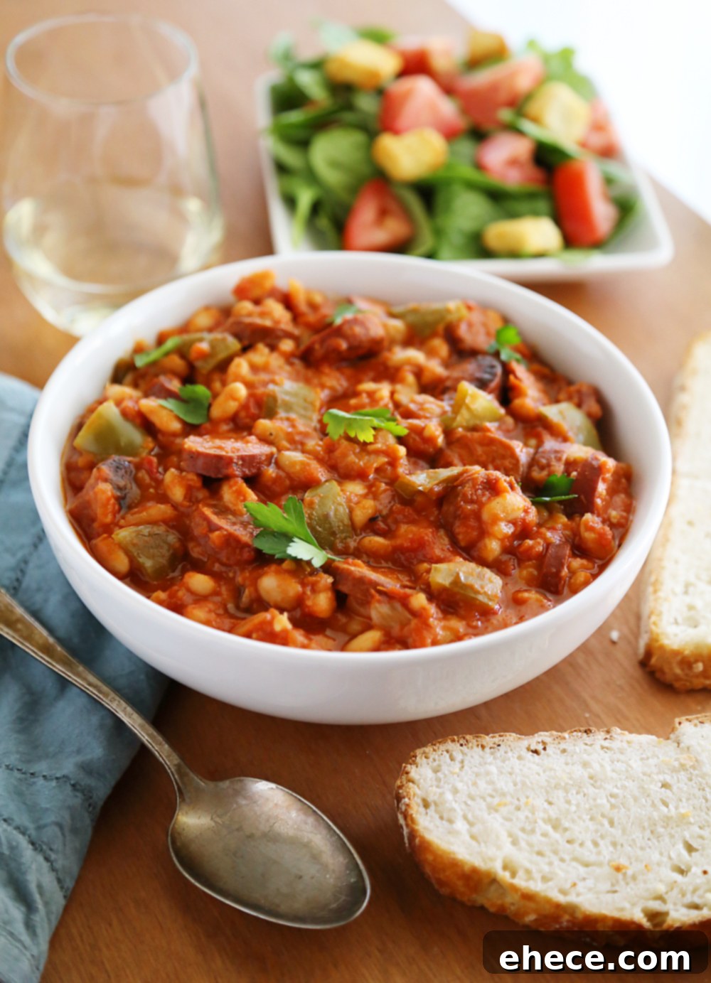 Savory Sausage, Peppers & White Bean Pot 4 Overhead view of slow cooker filled with sausage, peppers, onions, white beans, and crushed tomatoes before cooking.