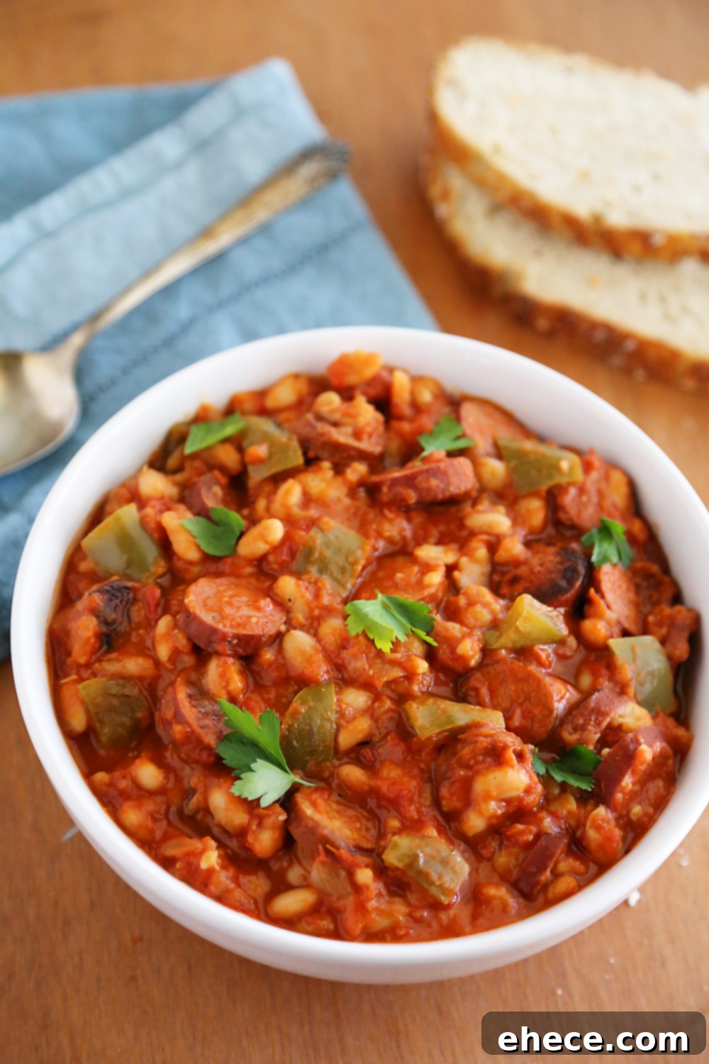 Savory Sausage, Peppers & White Bean Pot 5 Delicious bowl of slow cooker sausage, peppers, and white beans served with a side of crusty bread, ready to be enjoyed.