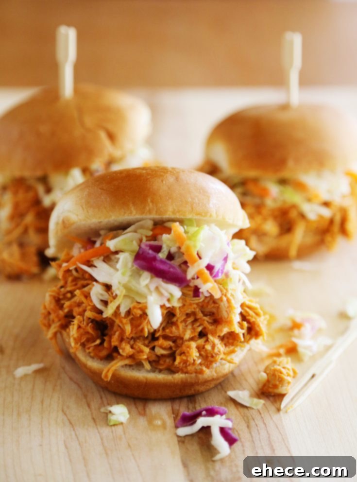 Slow Cooker Buffalo Chicken Sliders, a comforting and easy recipe from The Comfort of Cooking blog, garnished with fresh herbs.