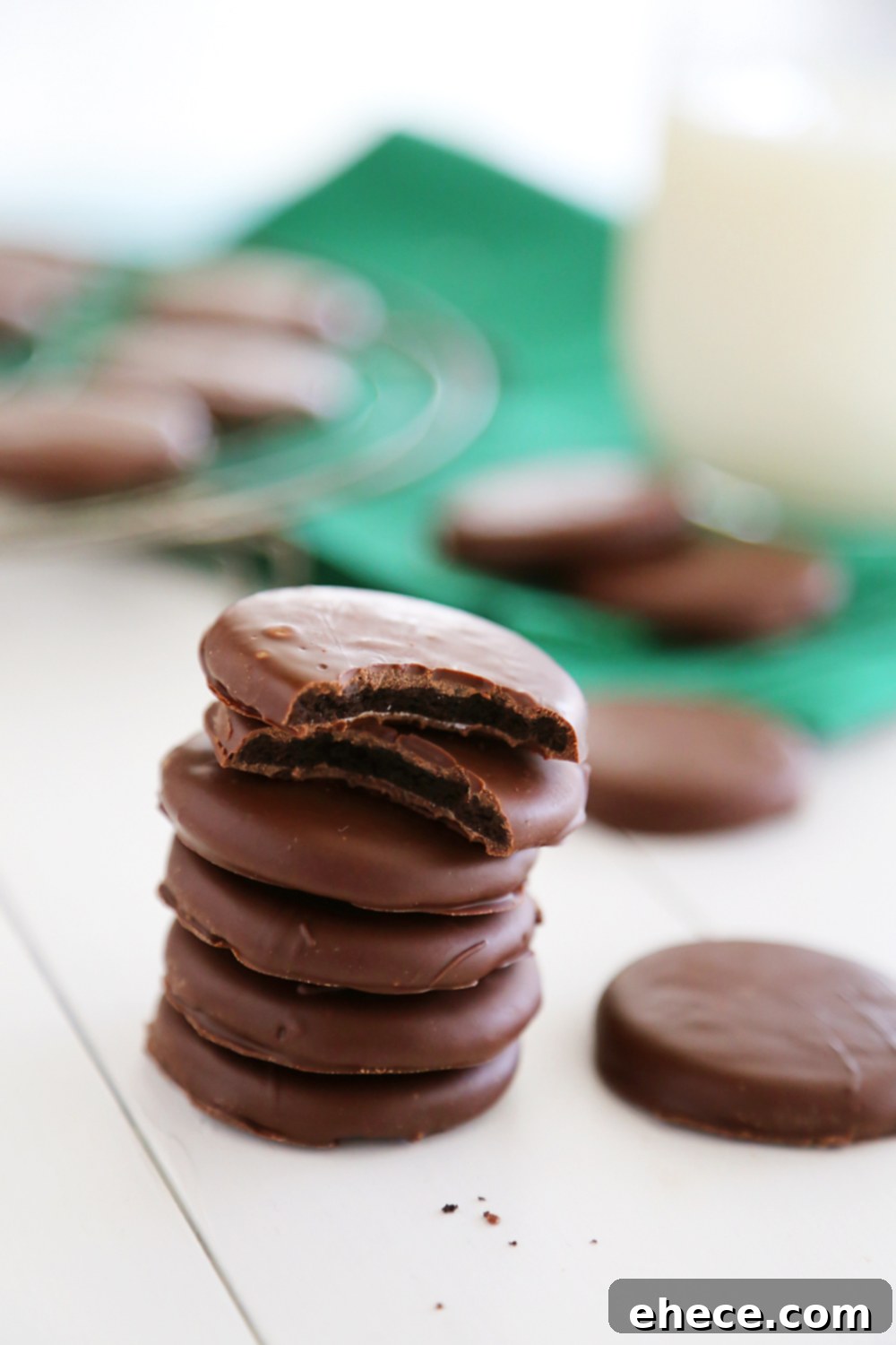 A close-up of a batch of homemade Oreo Thin Mints, perfectly coated in a smooth, glossy dark chocolate shell infused with refreshing peppermint.