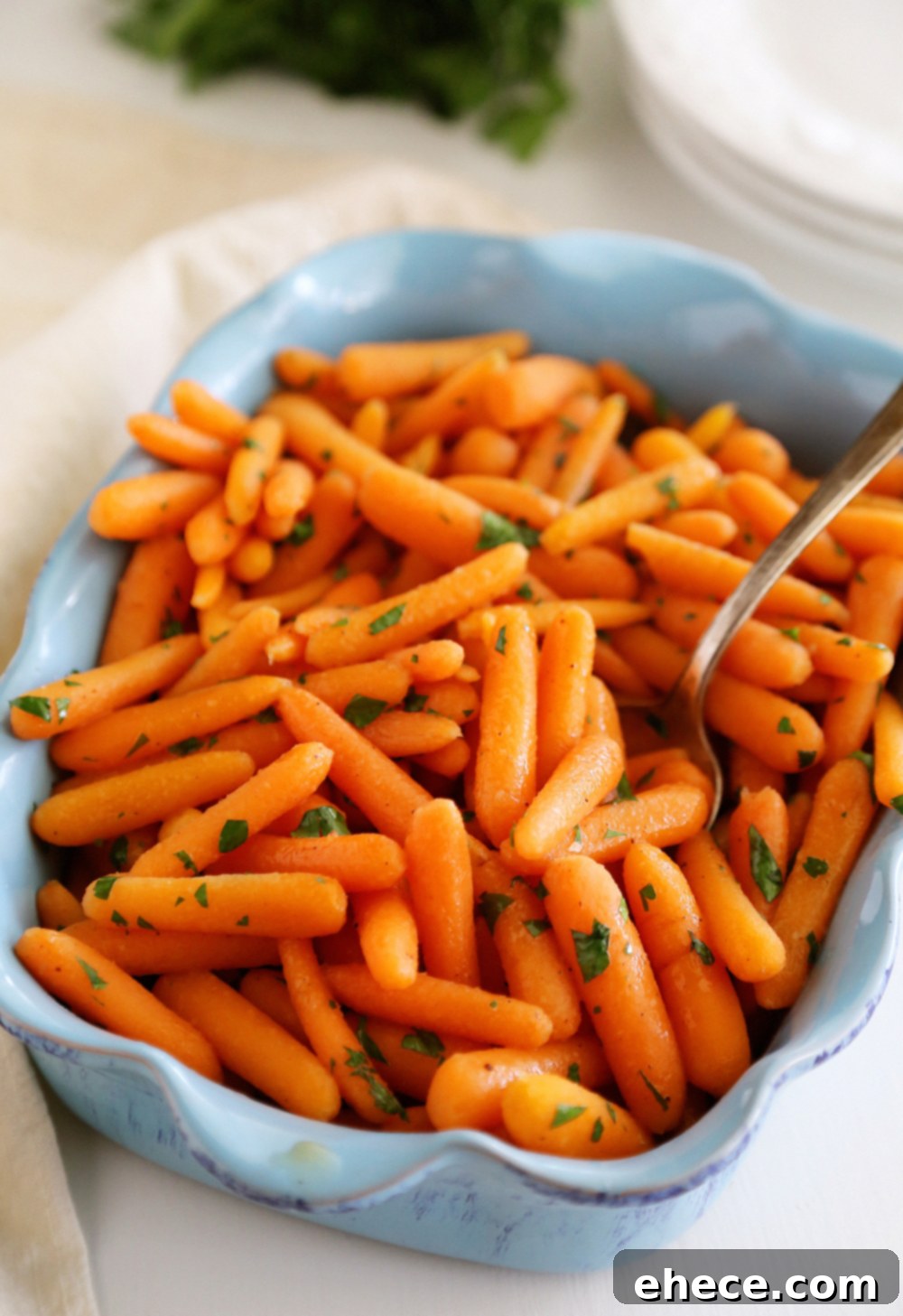 Vibrant honey-glazed baby carrots, glistening with a sweet butter sauce in a skillet, ready to serve.