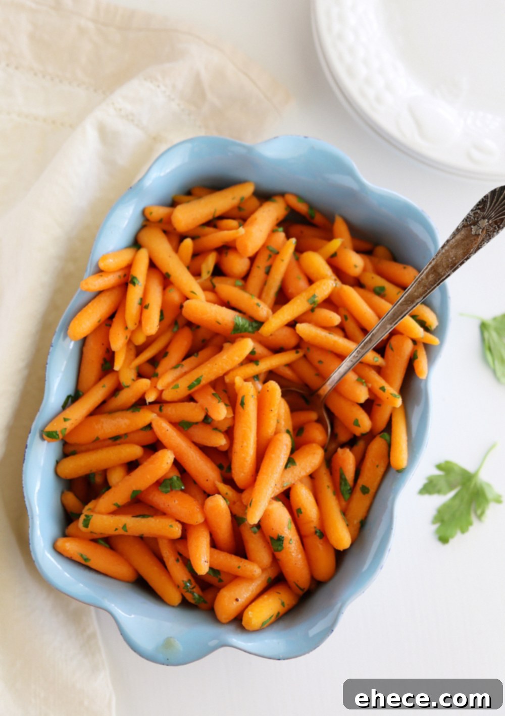 A second close-up image showing baby carrots beginning to soften and absorb flavors in the skillet.