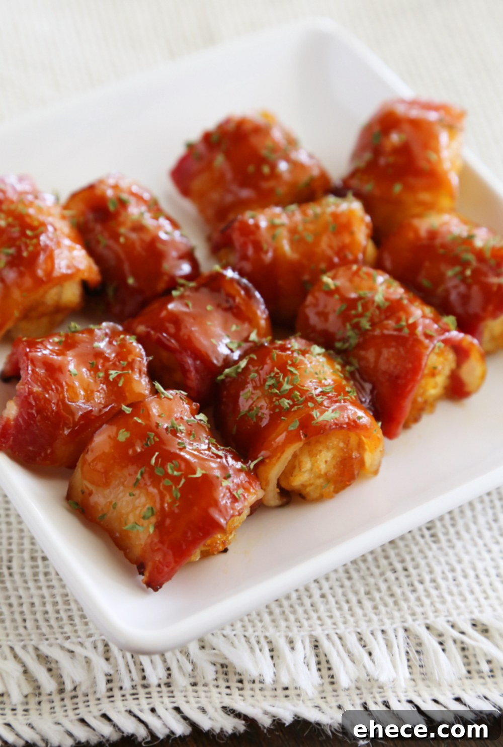 BBQ Bacon Wrapped Tater Tot Bites - Crispy tater tots wrapped in applewood smoked bacon and coated with a tangy homemade barbecue sauce! Thecomfortofcooking.com