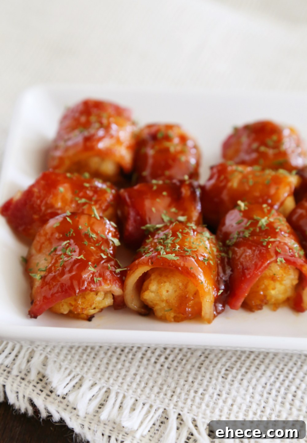 BBQ Bacon Wrapped Tater Tot Bites - Crispy tater tots wrapped in applewood smoked bacon and coated with a tangy homemade barbecue sauce! Thecomfortofcooking.com